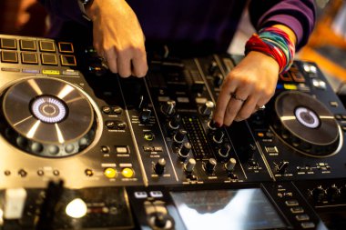 DJ, gece kulübündeki konsolda canlı set ve karışık müzik çalar. Disk Jokey Eller kulüp partisinde ses karıştırıcı istasyonunda. SEÇİM OKULU