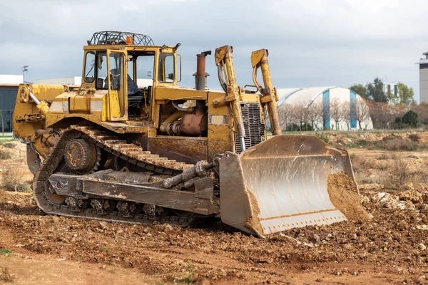 Dozer working at construction site. Bulldozer for land clearing, grading, utility trenching and foundation digging. Crawler tractor and earth-moving equipment