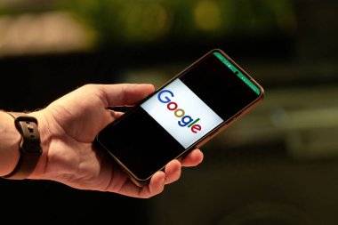 Antalya, Turkey - January 20, 2023: man hand holding Samsung S22 with social networking service Google on the screen.