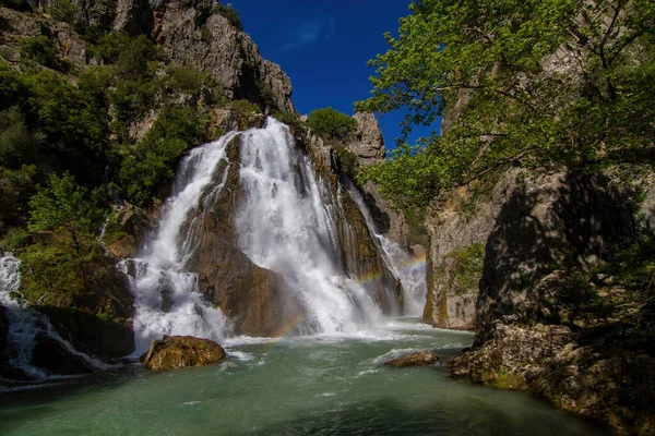 Dağ, büyük şelale ve kanyon akan göl arasında