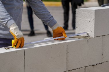 Tuğlacı ölçmek için çalışır. Bir metreyle ölçüyorum.