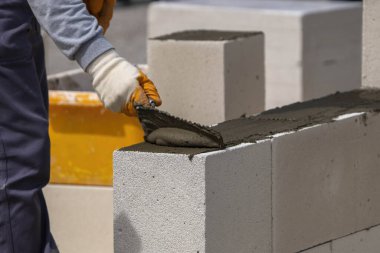 Tuğlacı çalışıyor. Havalandırmalı betondan bir duvar inşa etmek.