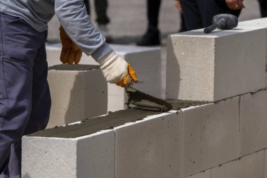 Tuğlacı çalışıyor. Havalandırmalı betondan bir duvar inşa etmek.