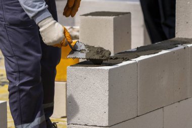 Tuğlacı çalışıyor. Havalandırmalı betondan bir duvar inşa etmek.