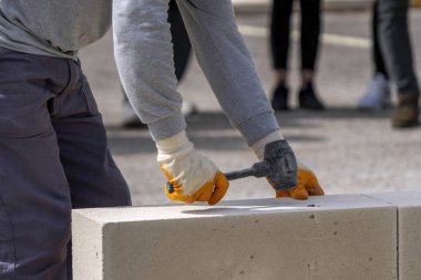 Tuğlacı çalışıyor. Havalandırmalı betondan bir duvar inşa etmek.