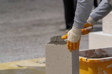 Tuğlacı çalışıyor. Havalandırmalı betondan bir duvar inşa etmek.