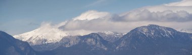 Karlı ve bulutlu dağların panoramik manzarası
