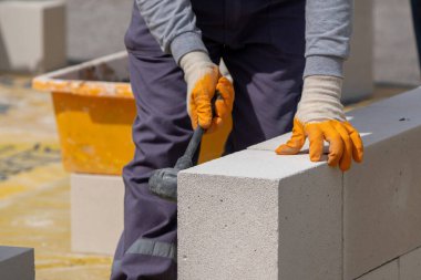 Tuğlacı çalışıyor. Havalandırmalı betondan bir duvar inşa etmek.