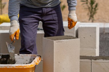 Tuğlacı çalışıyor. Havalandırmalı betondan bir duvar inşa etmek.