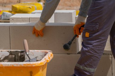 Tuğlacı çalışıyor. Havalandırmalı betondan bir duvar inşa etmek.