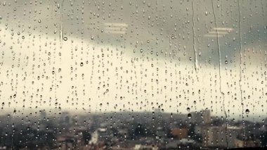Yağmurda damlalar pencereden aşağı düşüyor.