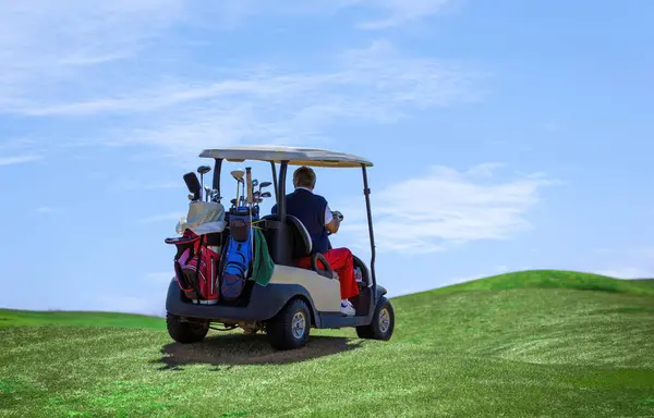 A man on the golf course with a golf cart