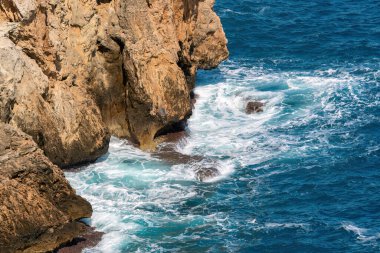Antalya Türkiye 'de derin mavi deniz dalgaları kayalara çarpıyor