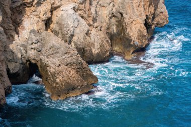 Antalya Türkiye 'de derin mavi deniz dalgaları kayalara çarpıyor