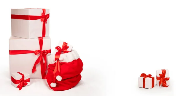 Świąteczna Kartka Torbą Mikołaja Obok Innych Prezentów Świątecznych Pudełka Zapakowane — Zdjęcie stockowe