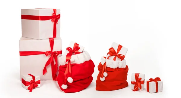 サンタクロースのバッグ クリスマスの杖と赤い帽子と白いテディベアと赤と白のクリスマスギフトボックスとクリスマスの背景 コピースペースと白に隔離された — ストック写真