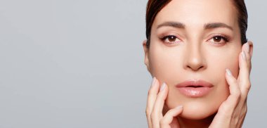 Güzellik ve cilt konsepti. Kusursuz cildinde çıplak makyajı olan orta yaşlı güzel bir kadın. Güzellik Yüzlü Spa Kadını,