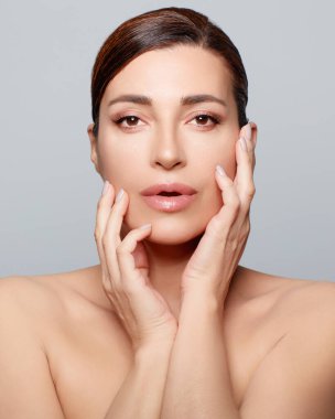 Ekolojik Makyaj ve Cilt Bakımı. Kusursuz cildinde çıplak organik makyajlı şehvetli sakin bir kadın. Dikey biçim