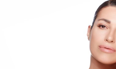 Güzellik ve cilt bakımı. Kusursuz bir ciltte çıplak makyajlı güzel model kız yüzü sakin bir ifadeyle kameraya bakıyor. Kapalı portre beyaz üzerinde izole