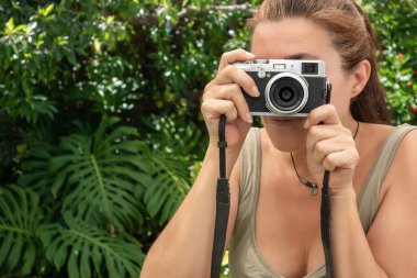 Dışarıda fotoğraf makinesiyle fotoğraf çeken güzel bir kadın. Kopyalama alanı ile yakın plan