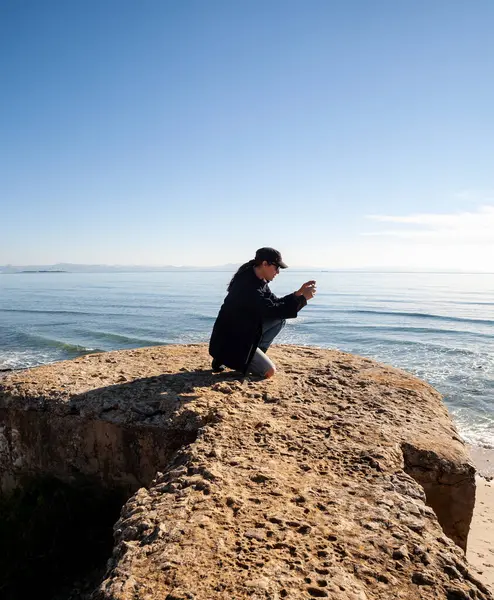 Женщина Фотографирует Чистое Небо Океан Скалистом Пляже Горизонт Над Водой — стоковое фото