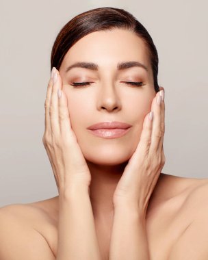 Orta yaşlı bir kadın kapalı bir kaplıca stüdyosunda gençleştirici bir güzellik tedavisi görüyor. Sağlıklı, nemli teni doğal güzelliğini arttırıyor..