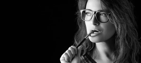 Young adult woman in black and white glasses against a black background with copy space.