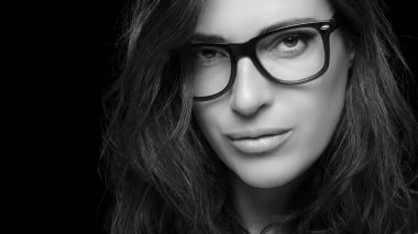 Close up Pretty Young Woman Face, with Glasses, Looking at Camera. Gorgeous Brunette Fashion Model Girl. Cool Trendy Eyewear Portrait with copy space