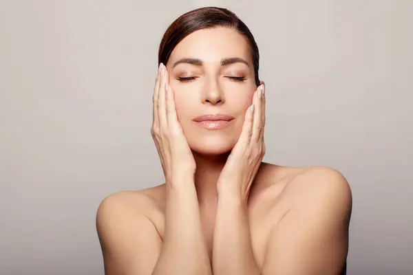 A relaxed young woman with closed eyes enjoys a rejuvenating spa treatment. Her face reflects beauty and wellbeing, showcasing the effectiveness of anti-aging skincare.