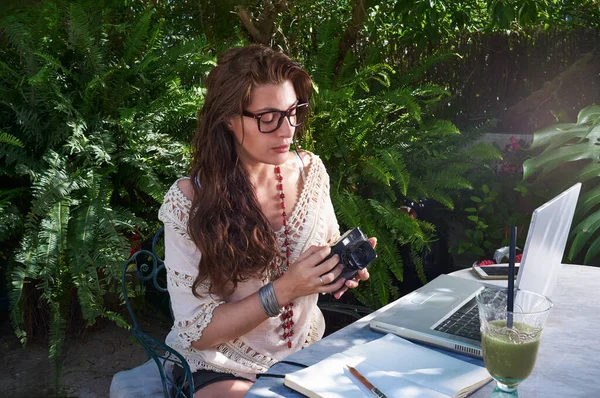 一位穿着随意的年轻女性 一边用相机工作 一边用游牧的方式交流 一边欣赏大自然 她在工厂之间学习技术 免版税图库图片