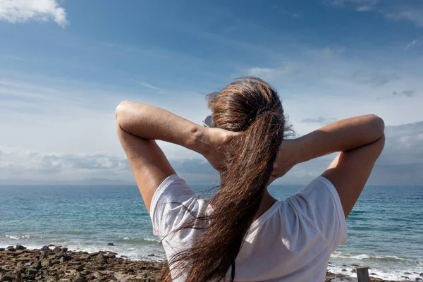 一个女人正在享受一个平静的时刻 看着平静的大海和天空 健康和度假项目的真实 坦率和梦幻的气氛 免版税图库照片