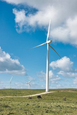 Güneşli bir günde yenilenebilir enerji için açık mavi gökyüzü olan yel değirmenleri. Çevre koruma kavramı.