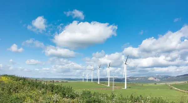 구름으로 뒤덮인 광대한 깨끗한 에너지를 생성하는 풍차가있는 고요한 로열티 프리 스톡 이미지