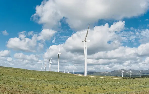 Sustainable Energy Concept Windmills Blue Cloudy Sky Spanning Rolling Green Fotos De Bancos De Imagens