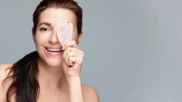 Joyful Woman Performs Rejuvenating Facial Massage Rose Quartz Gua Sha Stock Image