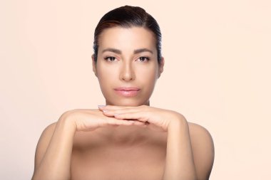 Stüdyo ortamında zarif bir şekilde poz veren orta yaşlı, güzel bir kadın. Boşluğu kopyala.