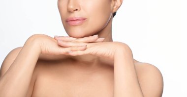 Spa, cilt bakımı ve sağlık. Sağlıklı tenli, elleri çenesinin altında beyaz arka planda poz veren güzel doğal bir kadın. Kopyalama alanı ile izole edilmiş.