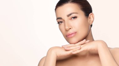 Cilt bakımında poz veren orta yaşlı, güzel bir kadın. Görüntü güzelliği, cilt bakımını ve doğal çekiciliği vurgular. Kopyalama alanı ile izole edilmiş.