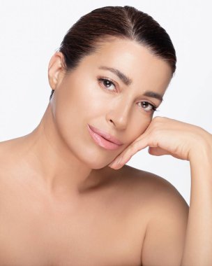 Güzel bir cildi ve sakin bir ifadesi olan, güzel bir orta yaşlı kadın. Güzellik ve cilt bakımına çok uygun. Kopyalama alanı olan beyaz bir arkaplanda izole edilmiş.