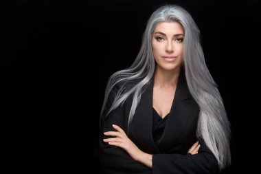 Portrait of a confident woman with long silver hair in a black suit against a dark studio background. Elegant and poised. clipart