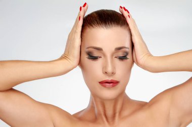 Zarif hatları ve kusursuz makyajı olan bir kadın gözleri kapalı, güzelliği ve zarafeti ön plana çıkaran pozlar verir. Tırnakları manikürlü. Güzellik ve moda teması için ideal. Yatay, boşluğu kopyala.