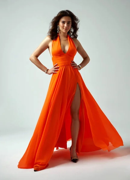 Sexy Módní Model Oranžové Šaty Vlnitým Účesem Ukazující Nohu — Stock fotografie