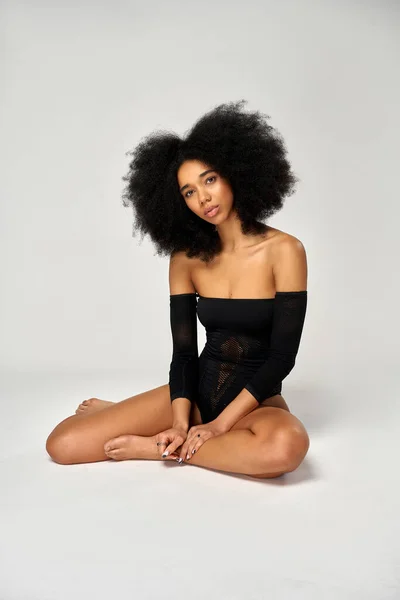 stock image Photo of african american girl with an afro hairstyle wear black mesh bodysuit sitting on the floor 