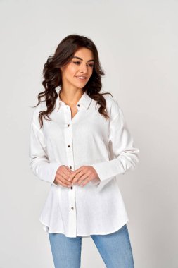 Gri arka planda izole edilmiş, boş alana bakan güzel genç bir kadın.,                               