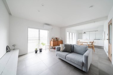 Beyaz tonlu, basit modern oturma odası.