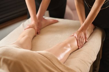 Kadın güzellik salonunda ayak masajı yaptırıyor.