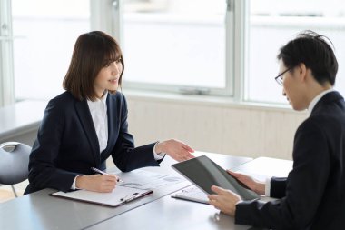 Asian business person showing and explaining a tablet