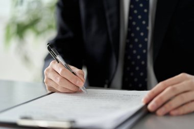 Asyalı işadamı belgelerin içeriğini kontrol ediyor