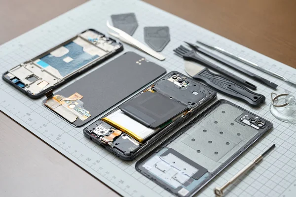 stock image Hands performing disassembly maintenance of smartphones