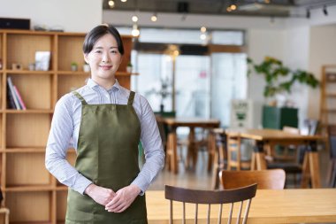 Mağazanın içinde duran bayan bir restoran çalışanı.